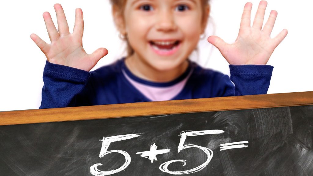 Girl Holding Up Ten Fingers Behind Chalkboard