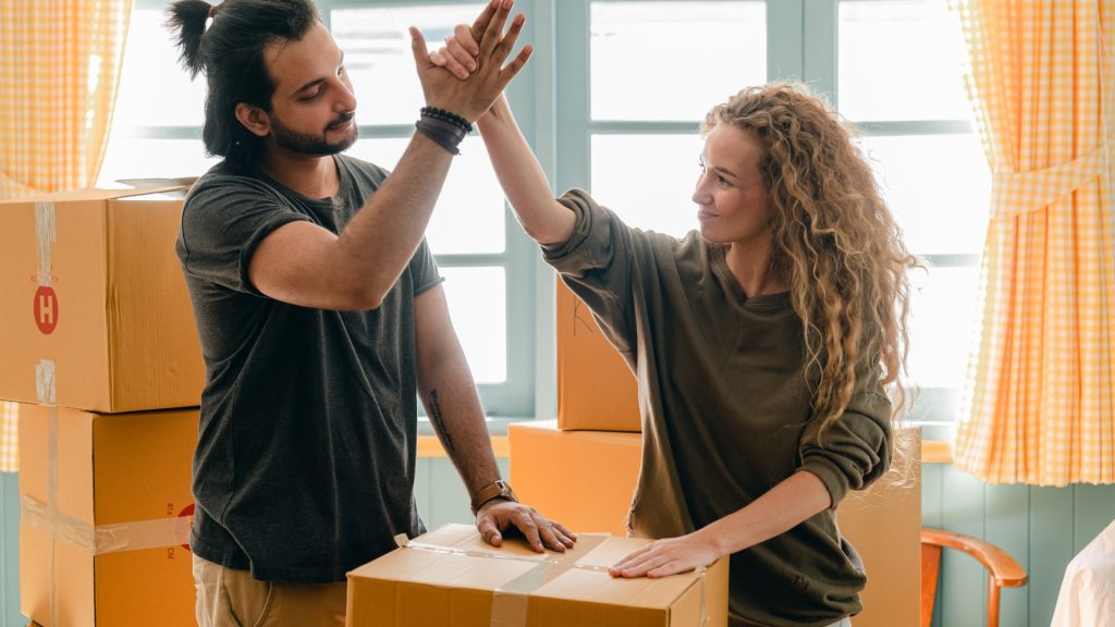 Man and Woman High Fiving Over Moving Box